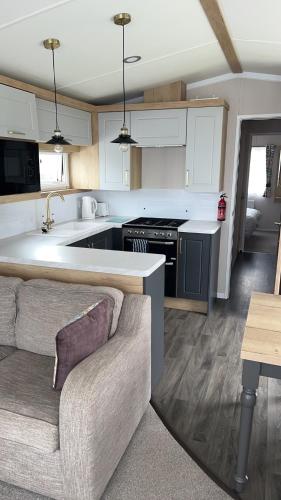 a kitchen with a couch and a stove top oven at B1 - Pebble Bank Caravan Park in Weymouth