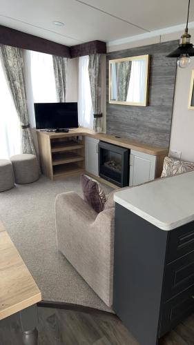 a living room with a couch and a fireplace at B1 - Pebble Bank Caravan Park in Weymouth
