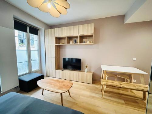 a living room with a television and a table at New studio fully furnished - Rue d'Enghien, Paris in Paris