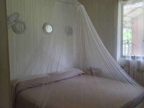 a bedroom with a bed with a mosquito net at Casa Cereza in Tierra Oscura