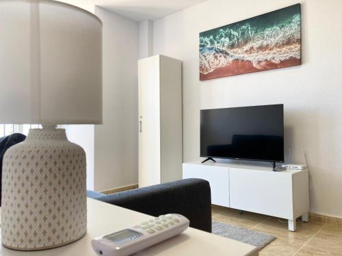a living room with a tv and a table with a remote control at Casa Lilla - Ideal for couples in Los Alcázares