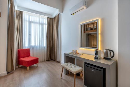 ein Hotelzimmer mit einem Schreibtisch und einem roten Stuhl in der Unterkunft My Hotel in Antalya