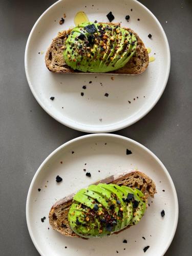 two plates with sandwiches with avocado on them at Aethra Cave Suites in Pyrgos