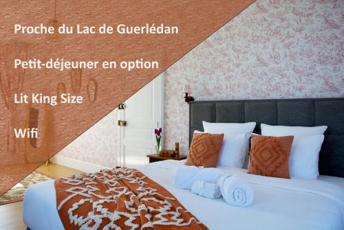 Valfrescos - Lac de Guerlédan في Caurel: غرفة نوم مع سرير كبير مع وسائد برتقالية
