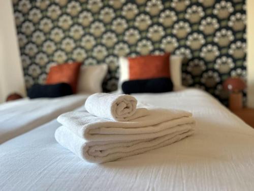a pile of towels sitting on top of a bed at Le Tinailler Grand Standing au Cœur des Vignes in Prissé