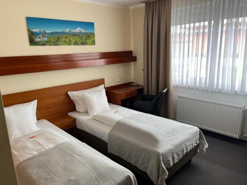 a hotel room with two beds and a window at Hotel Zum Ritter in Seligenstadt