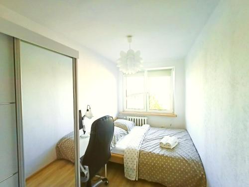 a bedroom with a bed and a chair and a window at Great apartament, near forest and with sea view in Sopot