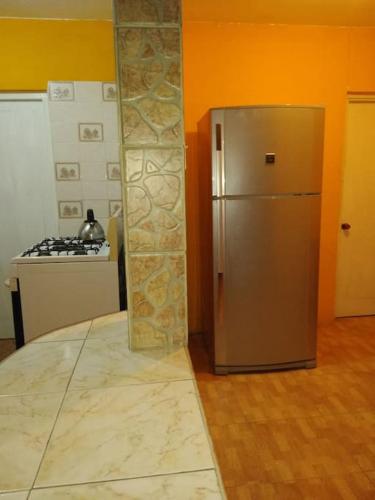 a stainless steel refrigerator in a kitchen next to a stove at Queste Ochi Town House in Ocho Rios