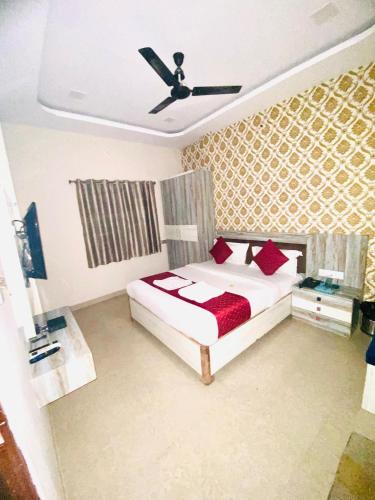 een slaapkamer met een bed met rode kussens bij Hotel vinayak in Indore