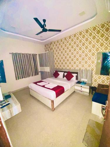 a bedroom with a bed and a ceiling fan at Hotel vinayak in Indore
