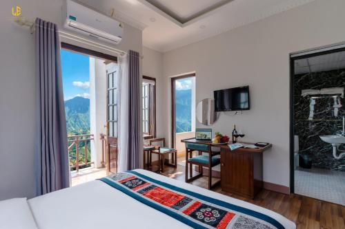 Un dormitorio con una cama y un escritorio y un balcón. en Le Boutique Sapa Hotel, en Sa Pa