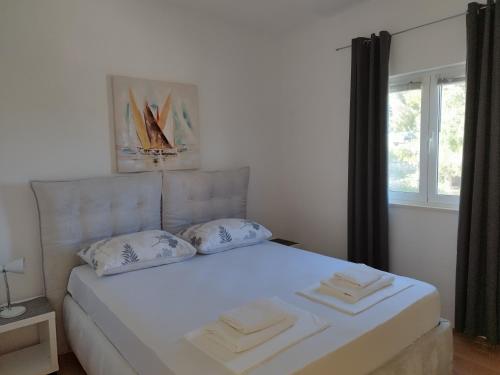 a white bed with two pillows in a bedroom at Brzica Saplunara in Saplunara