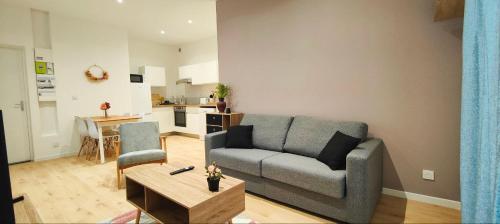 - un salon avec un canapé et une table dans l'établissement Appartements à thème, à Clermont-Ferrand