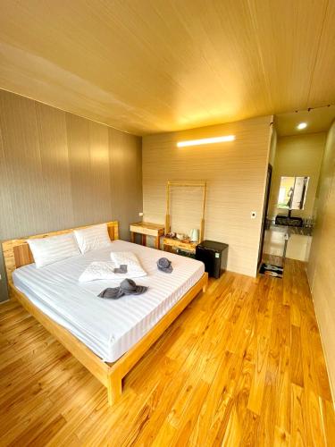a large bed in a room with a wooden floor at Jewel Homestay in Hai Phong