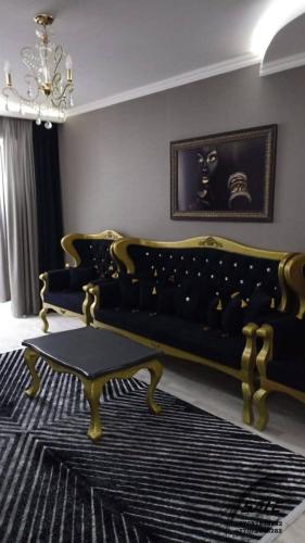 un soggiorno con panca e lampadario pendente di Элитная 2-комнатная квартира в районе Болашак a Kooperator