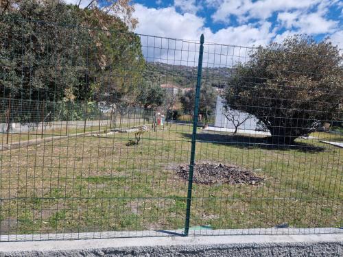 una recinzione con un albero in un parco di Villetta 28 (passi dal mare) ad Acquappesa