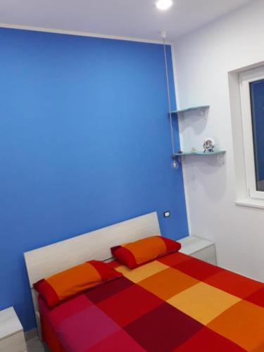 una camera con un letto con una coperta colorata di Villetta 28 (passi dal mare) ad Acquappesa