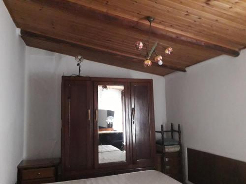 a bedroom with a wooden ceiling and a mirror at B&B Domo De Pedra in Tottubella