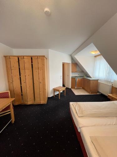 an attic room with two beds and wooden cabinets at Hotel-Landpension Postwirt in Kirchensittenbach