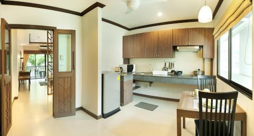 eine Küche mit einem Kühlschrank und einem Tisch im Zimmer in der Unterkunft Ratana Hill Patong in Patong Beach