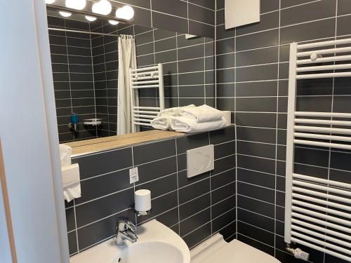 een badkamer met een wastafel en een spiegel bij Hotel Zum Ritter in Seligenstadt