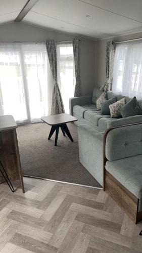 a living room with a couch and a table at T23- Pebble Bank Caravan Park in Weymouth