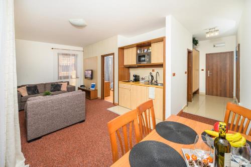 a kitchen and a living room with a dining table at Apartmány Paula F 302 in Veľká Lomnica