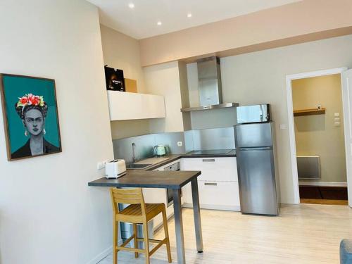 una cucina con tavolo e frigorifero di Emplacement idéal Confort et tranquillité a Boulogne-sur-Mer