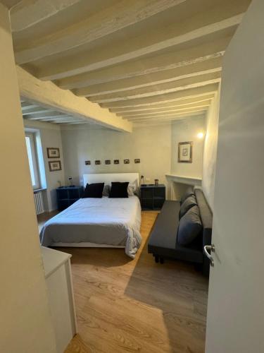 a bedroom with a large bed and a couch at Beautiful Center Apartments - posti auto privati prenotabili in Parma