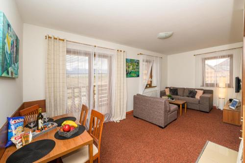 a living room with a table and a dining room at Apartmány Paula F 302 in Veľká Lomnica