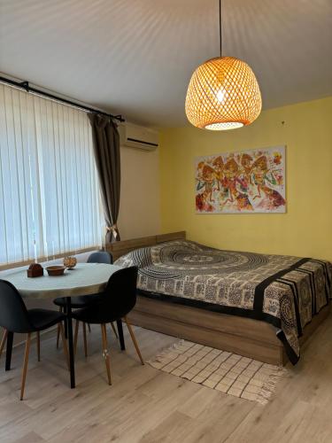 um quarto com uma cama e uma mesa com cadeiras em Студио Хармония -Supreme apartments-Балчик em Balchik