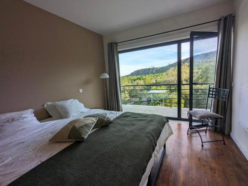 1 dormitorio con cama y ventana grande en Casa Boho - Turismo Rural, en Alvados