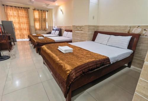 2 Betten in einem Zimmer mit 2 Tischen in der Unterkunft KHÁCH SẠN Như Ý in Ho-Chi-Minh-Stadt