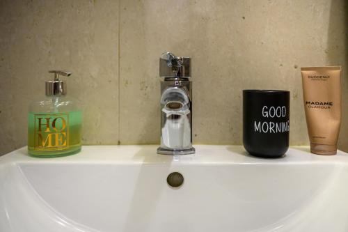 a bathroom sink with a soap dispenser and a bottle at Apartmány Paula F 302 in Veľká Lomnica