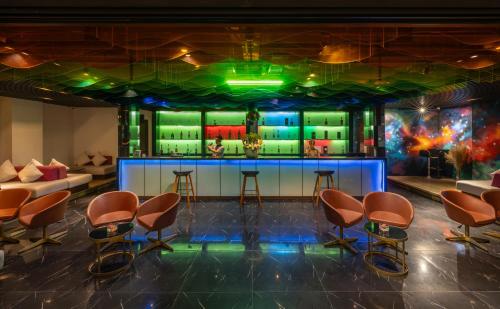 a bar in a room with chairs and a couch at Satya Da Nang Hotel Han Market in Da Nang