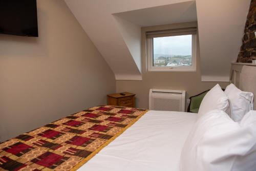 a bedroom with a bed and a window at Donegal House in Donegal