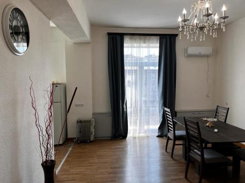 une salle à manger avec une table et un lustre dans l'établissement Komitas Apartement, à Erevan