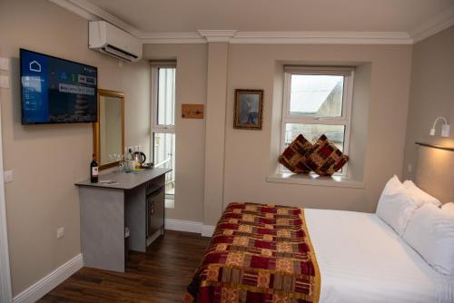 a bedroom with a bed and a sink and a window at Donegal House in Donegal