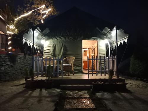 ein Zelt mit einem Tisch und Stühlen in der Nacht in der Unterkunft YOLO RESORT in Dharān Bāzār