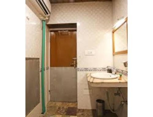 een badkamer met een douche en een wastafel bij Hotel Yemberzal & Restaurant, Jammu and Kashmir in Gulmarg