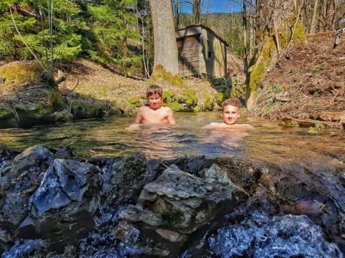 two boys swimming in a stream in the woods at Penzion Pichberg Horská chata in Rokytnice nad Jizerou