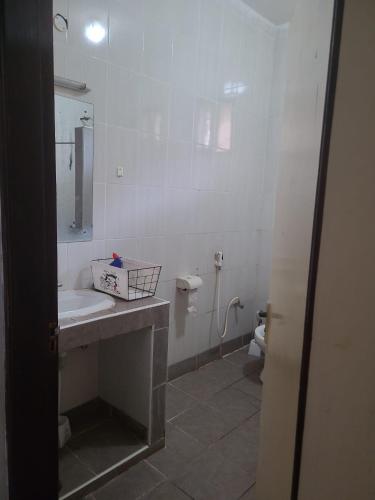 a white bathroom with a sink and a toilet at Picho two bedroom apartment in Malindi
