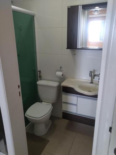 a bathroom with a toilet and a sink at Apartamento frente mar pé na areia in Praia Grande