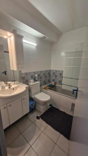 une salle de bain avec un lavabo, des toilettes et une baignoire dans l'établissement CLOS ST CYPRIEN Superbe T2 proche plage et port - terrasse - Piscine - parking, à Saint-Cyprien