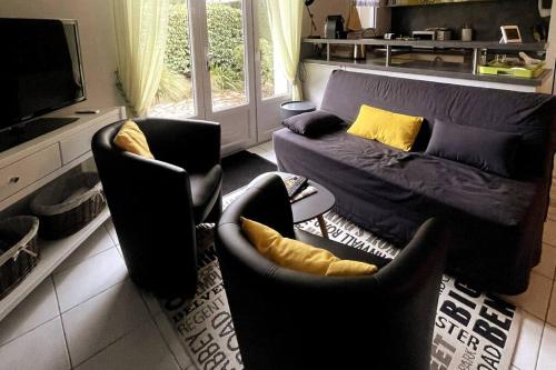 un salon avec deux chaises et un canapé dans l'établissement L'authentique - Cosy & Calme, à La Pironnière