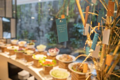 a table with many bowls of food on it at Satya Da Nang Hotel Han Market in Da Nang