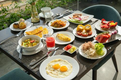 a table with plates of food on it at Satya Da Nang Hotel Han Market in Da Nang
