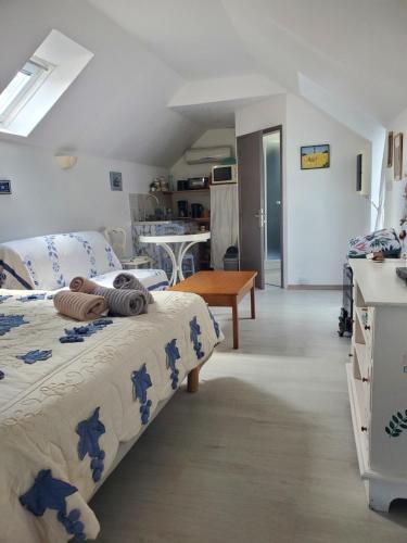 ein Schlafzimmer mit 2 Betten und eine Küche mit einem Tisch in der Unterkunft Gîtes An Douar Menez in Gourin