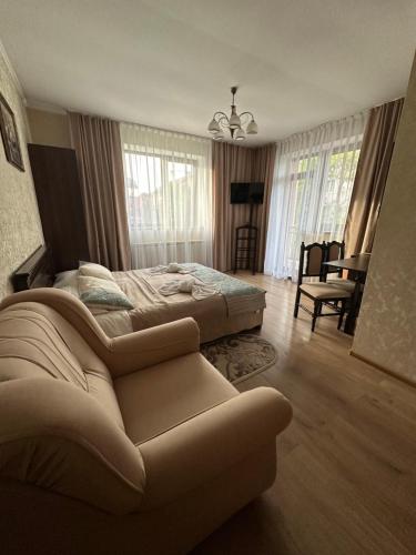 1 dormitorio con 1 cama grande y 1 sofá en Сонячна Перлина, en Polyana