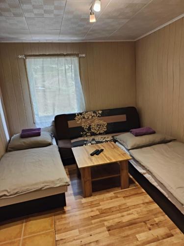 a room with two beds and a table in it at Chata 2 na Poľane in Hriňová